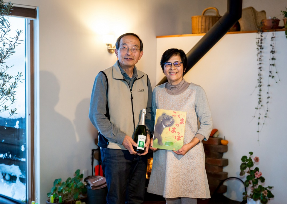 Honma san couple with wine and picture book in hand